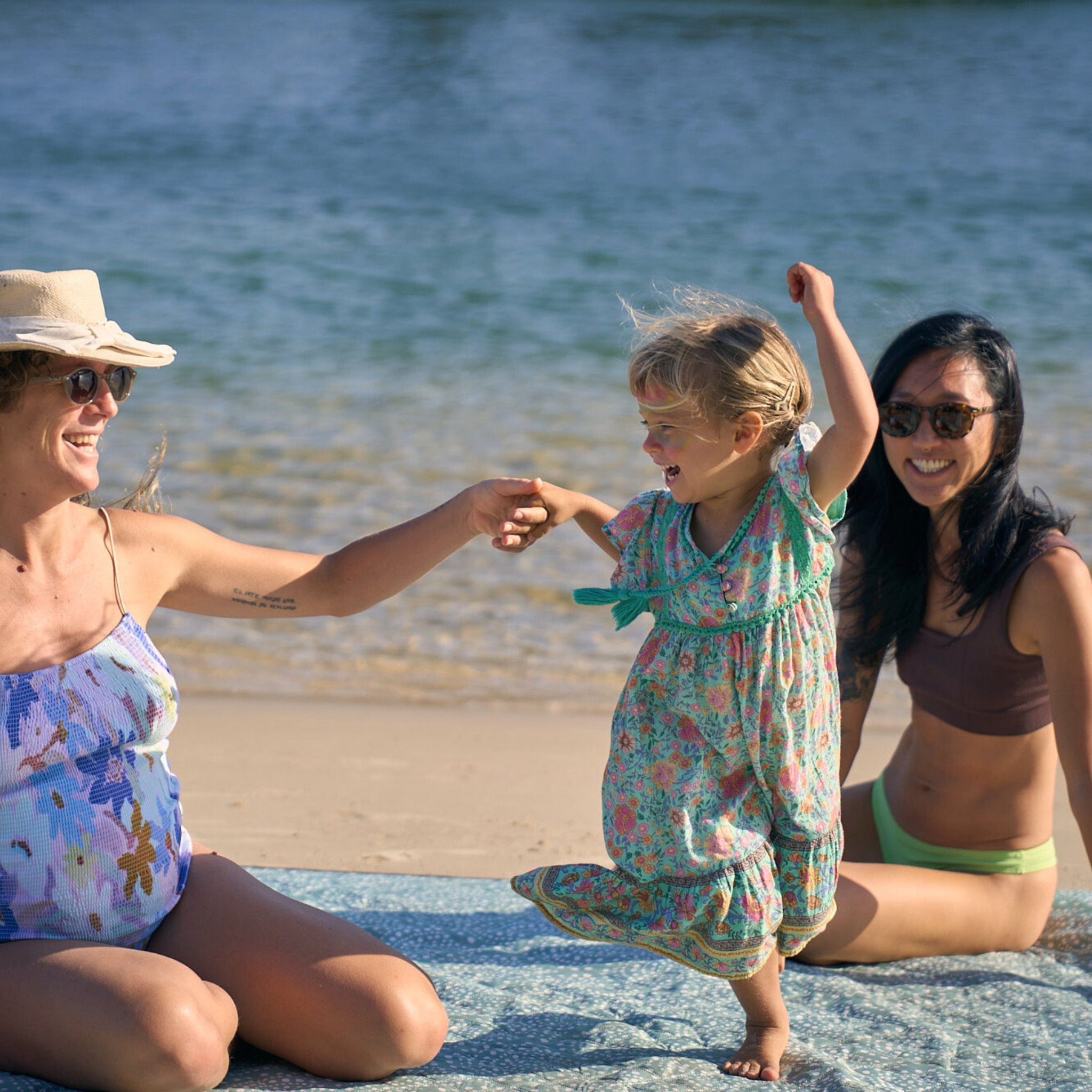 Friends and family enjoying the extra-large Snapper Rocks Beach Mate together by the water.