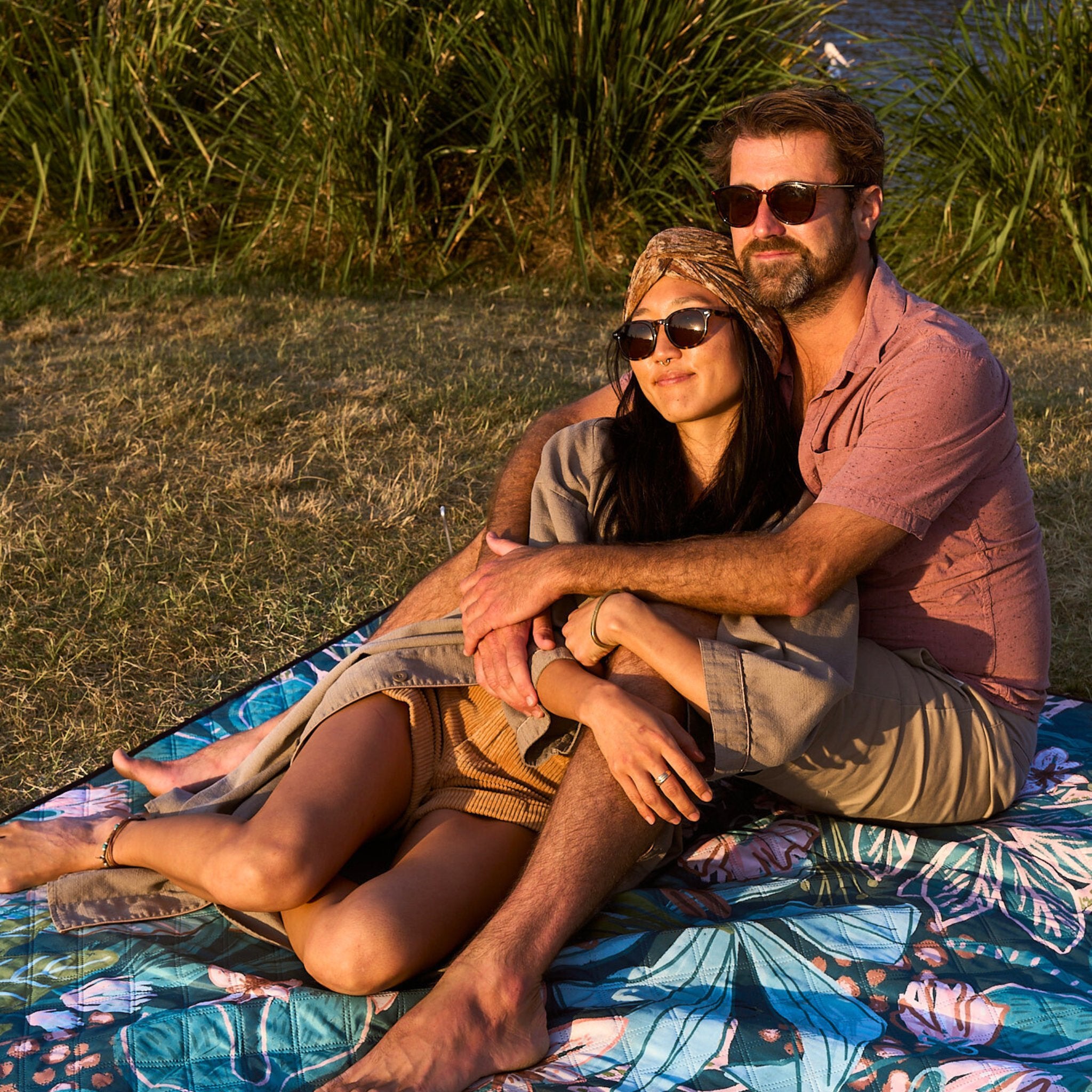 Couple sitting together on the Talle Valley Beach Mate, enjoying the sunset.