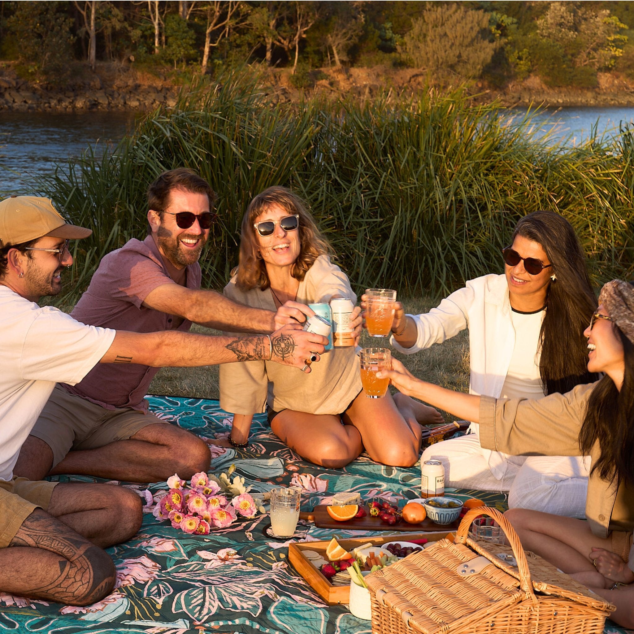 Group toasting drinks and sharing a picnic on the Talle Valley Beach Mate.