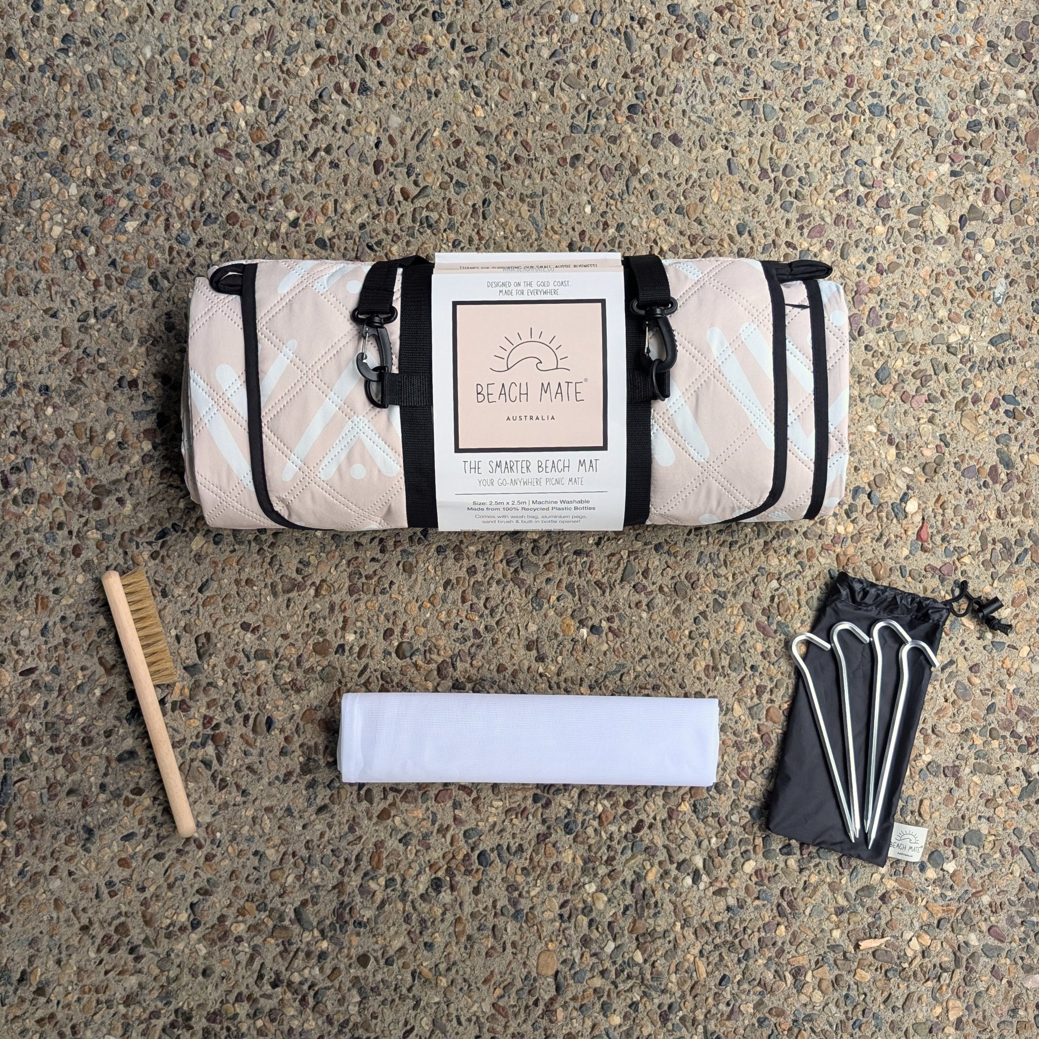 Beach Mate Palm Beach sand-free recycled beach mat flatlay showing included accessories — sand brush, wash bag, and aluminium pegs.